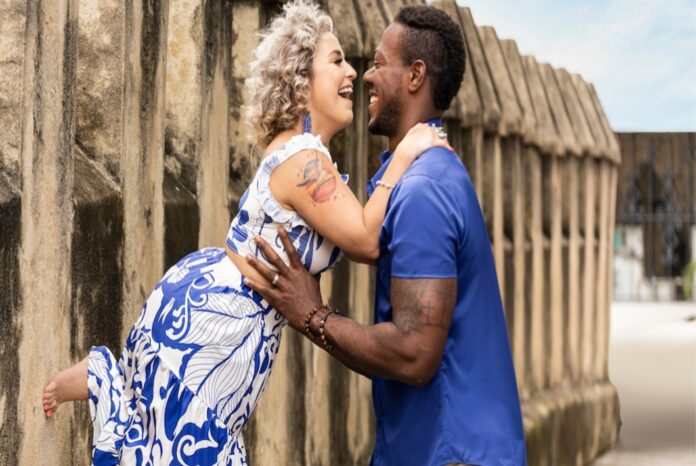 Couple sharing a joyful moment outdoors, leaning in for a kiss. Couple sharing a joyful moment outdoors, leaning in for a kiss.