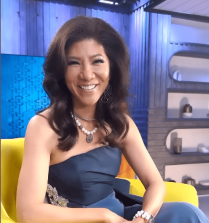A smiling woman in a strapless dress sitting on a yellow chair in a modern studio. A smiling woman in a strapless dress sitting on a yellow chair in a modern studio.