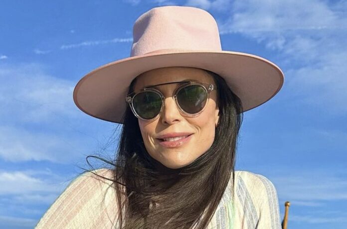Woman wearing a pink hat and sunglasses outdoors. Woman wearing a pink hat and sunglasses outdoors.