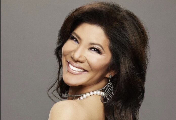 Smiling woman with dark hair and pearl necklace against gray background. Smiling woman with dark hair and pearl necklace against gray background.