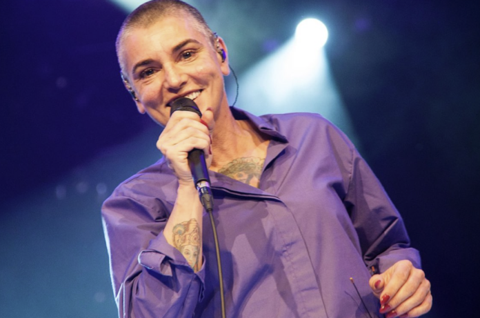 A smiling singer performs on stage with a microphone. A smiling singer performs on stage with a microphone.