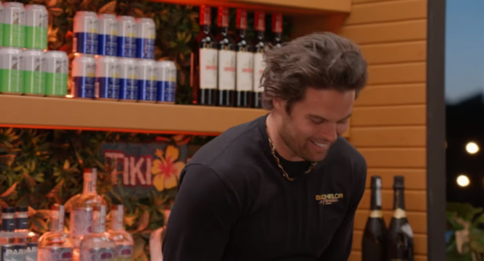 Man smiling in a store with shelves of wine and canned drinks behind him. Man smiling in a store with shelves of wine and canned drinks behind him.