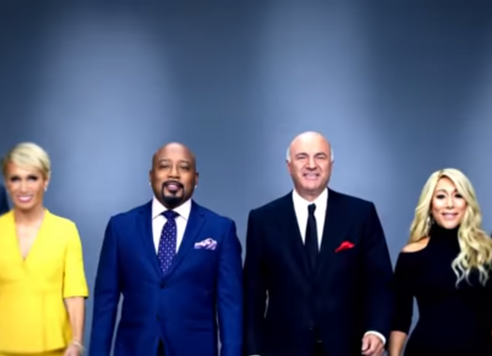 Four professionals in formal attire posing against a plain blue background. Four professionals in formal attire posing against a plain blue background.