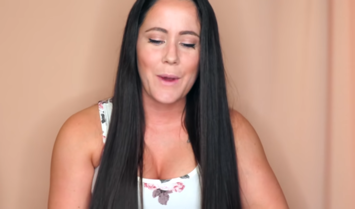 Woman with long dark hair wearing a floral top against a peach background. Woman with long dark hair wearing a floral top against a peach background.
