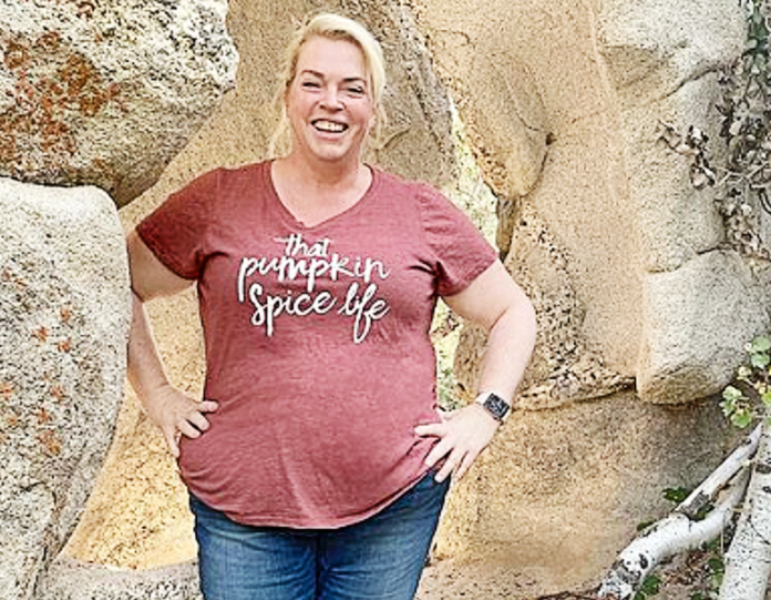Woman smiling outdoors wearing a pumpkin spice life t-shirt. Woman smiling outdoors wearing a pumpkin spice life t-shirt.