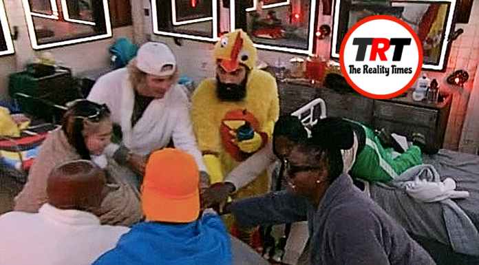 People gathered around a table, one dressed in a chicken costume. People gathered around a table, one dressed in a chicken costume.