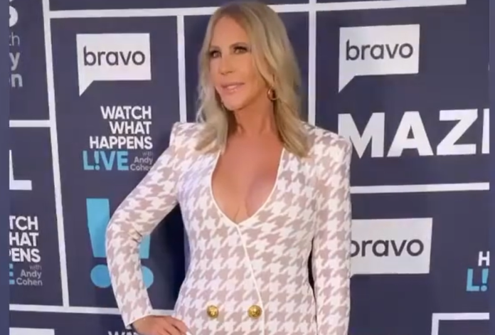 Woman posing on a Bravo event red carpet in a patterned blazer. Woman posing on a Bravo event red carpet in a patterned blazer.