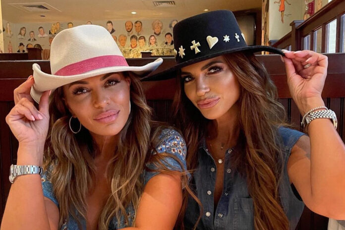 Two women wearing stylish hats pose closely together indoors. Two women wearing stylish hats pose closely together indoors.