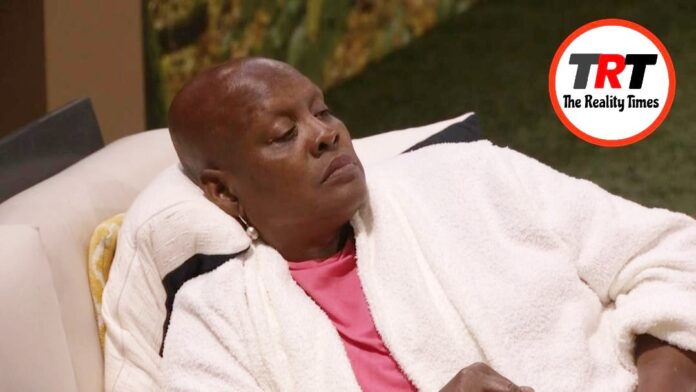 A person resting with eyes closed, wearing a white robe and pink shirt. A person resting with eyes closed, wearing a white robe and pink shirt.