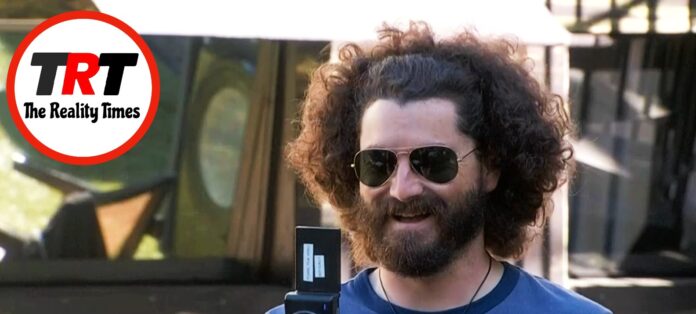 Man with curly hair and sunglasses smiling outdoors. Man with curly hair and sunglasses smiling outdoors.