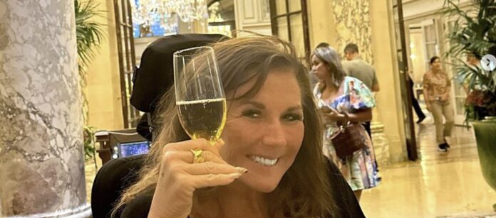 Woman smiling and holding a glass of champagne in a lively setting. Woman smiling and holding a glass of champagne in a lively setting.