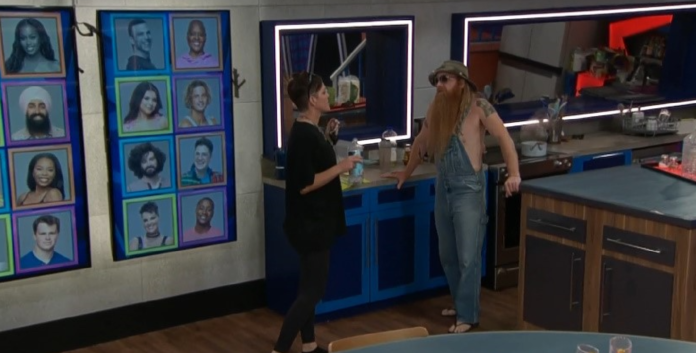Two women talking in a room with blue lockers and portraits on the wall. Two women talking in a room with blue lockers and portraits on the wall.