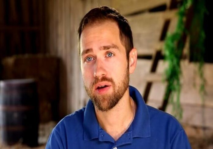 A man with a beard wearing a blue polo shirt indoors. A man with a beard wearing a blue polo shirt indoors.