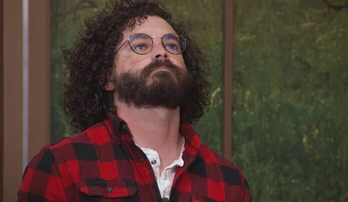 Man with curly hair and glasses wearing a red plaid shirt. Man with curly hair and glasses wearing a red plaid shirt.