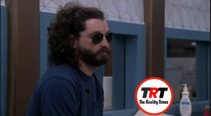Man with curly hair and sunglasses sitting indoors. Man with curly hair and sunglasses sitting indoors.