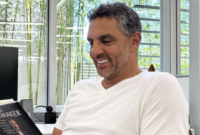 Man smiling and looking down, wearing a white shirt indoors. Man smiling and looking down, wearing a white shirt indoors.