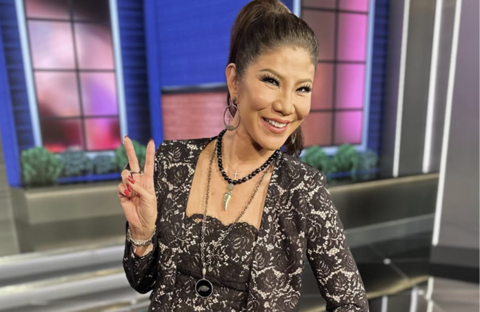 Smiling woman posing with a peace sign in a studio setting. Smiling woman posing with a peace sign in a studio setting.