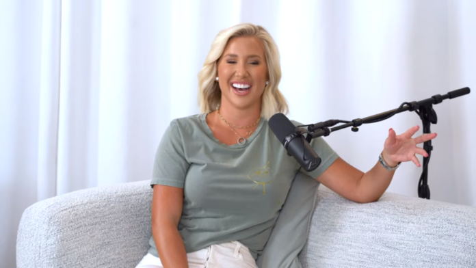 Smiling woman in casual clothes sitting with a microphone. Smiling woman in casual clothes sitting with a microphone.