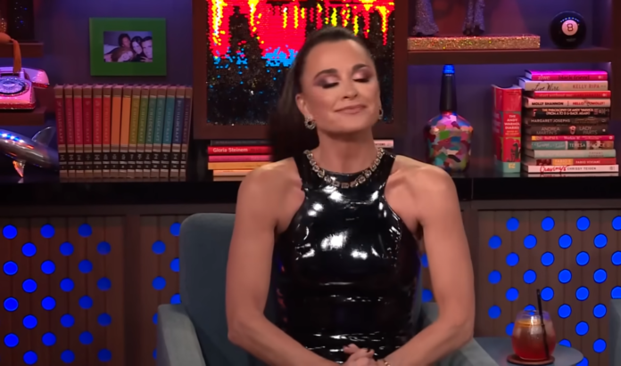 A woman in a shiny black dress with a satisfied expression. A woman in a shiny black dress with a satisfied expression.
