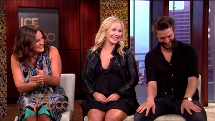 Three people sitting and smiling during a talk show. Three people sitting and smiling during a talk show.