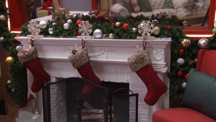 Two red Christmas stockings hanging from a decorated fireplace mantel. Two red Christmas stockings hanging from a decorated fireplace mantel.