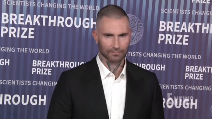 Man in a suit at a backdrop with text. Man in a suit at a backdrop with text.