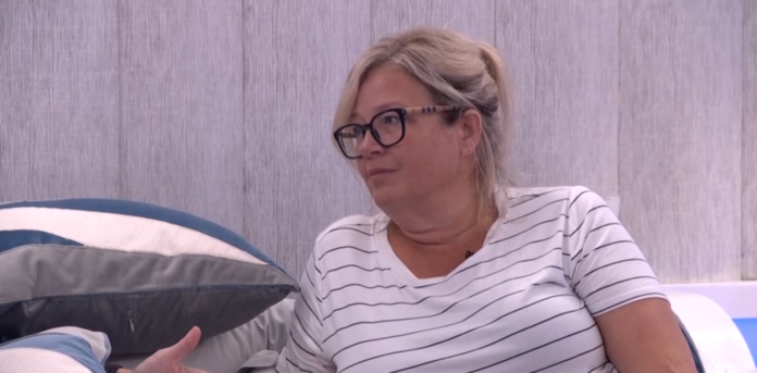 Woman with glasses sitting on a couch, wearing a striped shirt. Woman with glasses sitting on a couch, wearing a striped shirt.