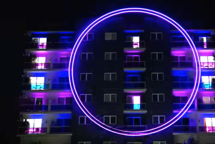 Neon lights create vibrant patterns on a building at night. Neon lights create vibrant patterns on a building at night.