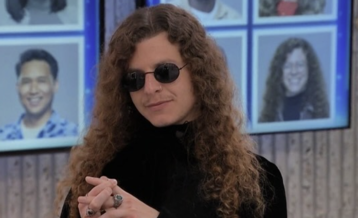 Person with long curly hair and sunglasses smiling indoors. Person with long curly hair and sunglasses smiling indoors.