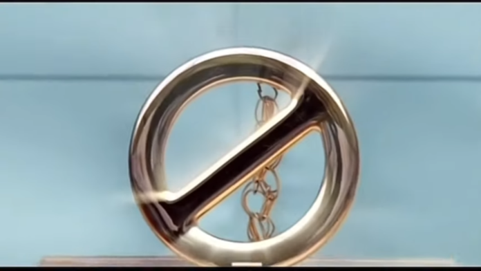 A shiny metallic circular object with a bar and chain inside. A shiny metallic circular object with a bar and chain inside.
