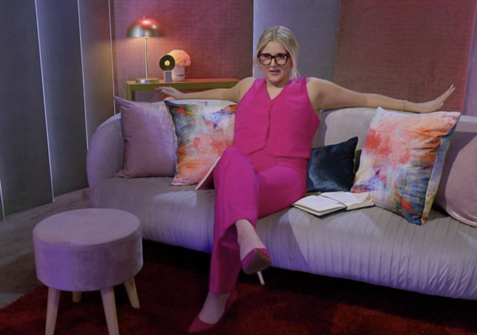 Woman in bright pink outfit sitting on a modern couch in a stylish room. Woman in bright pink outfit sitting on a modern couch in a stylish room.