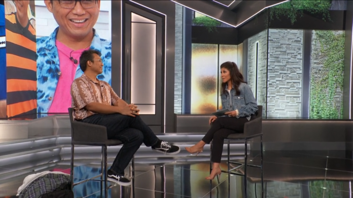 Two people having a conversation in a modern studio with glass walls. Two people having a conversation in a modern studio with glass walls.