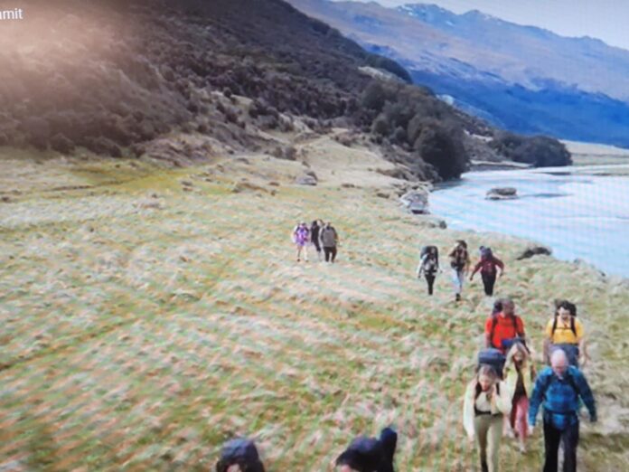 Hikers walking along a scenic mountain trail beside a river. Hikers walking along a scenic mountain trail beside a river.