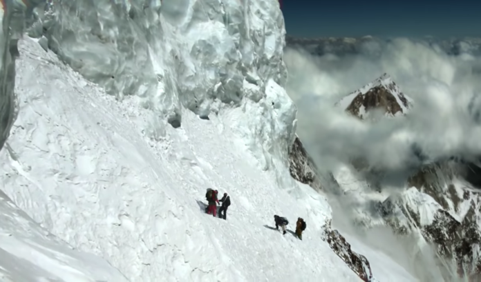 Climbers ascend a steep, icy mountain slope amid harsh snowy conditions. Climbers ascend a steep, icy mountain slope amid harsh snowy conditions.