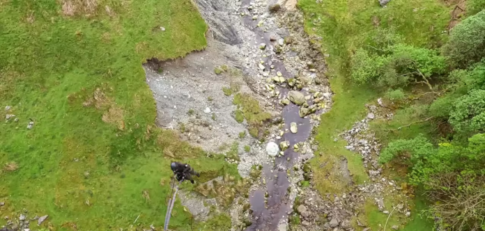 A shallow rocky stream flowing through grassy terrain. A shallow rocky stream flowing through grassy terrain.