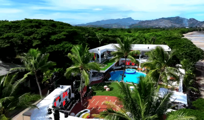 A tropical resort with a pool and lush greenery under a clear sky. A tropical resort with a pool and lush greenery under a clear sky.