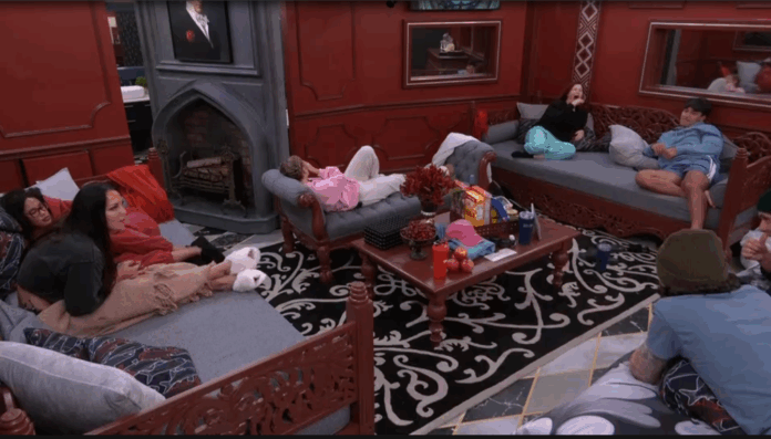People lounging and chatting in a cozy room with red walls and dark furniture. People lounging and chatting in a cozy room with red walls and dark furniture.