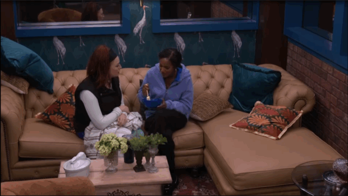 Two women sitting and chatting on a couch in a cozy living room. Two women sitting and chatting on a couch in a cozy living room.