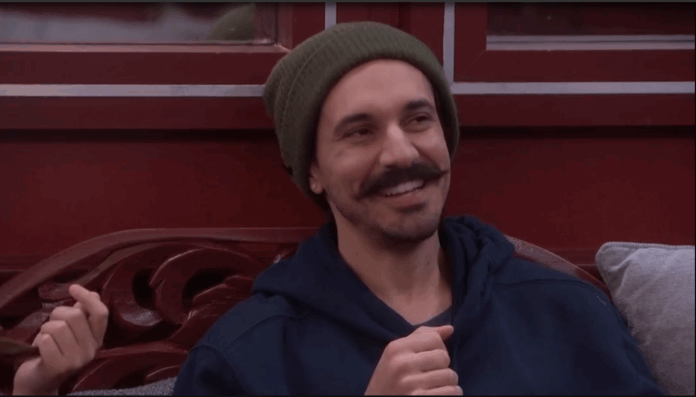 A man with a mustache and beanie smiling warmly. A man with a mustache and beanie smiling warmly.