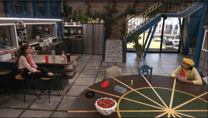 Cozy indoor café with plants, modern decor, and a bowl of strawberries on the table. Cozy indoor café with plants, modern decor, and a bowl of strawberries on the table.