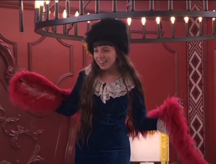 Woman in a blue velvet dress and black fur hat with red feathered gloves. Woman in a blue velvet dress and black fur hat with red feathered gloves.