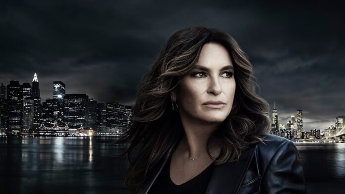 A woman with wavy hair stands against a dark cityscape at night. A woman with wavy hair stands against a dark cityscape at night.