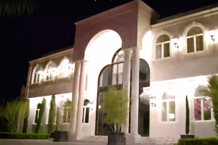 Elegant mansion entrance illuminated at night with arched doorway. Elegant mansion entrance illuminated at night with arched doorway.