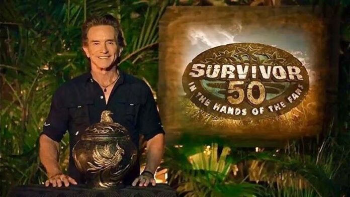 Host standing next to the Survivor 50 logo with a trophy. Host standing next to the Survivor 50 logo with a trophy.